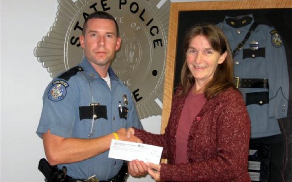 Aaron Turcotte, Treasurer of the Maine State Troopers Foundation, presents a check to Vicki Dill of the Maine Chapter of Murdered Children.