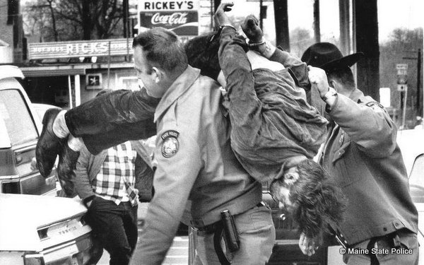 Trooper Dave Staples carries a suspect into court, and Trooper Ray Lamontagne assisting